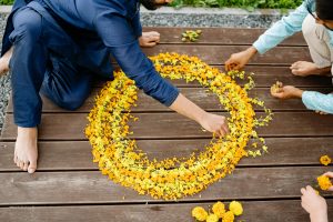 man decorating rangoli with flowers image