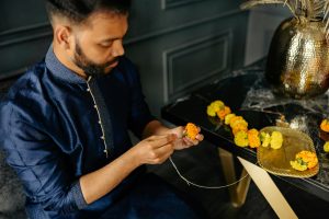 man decorating flowers toran image